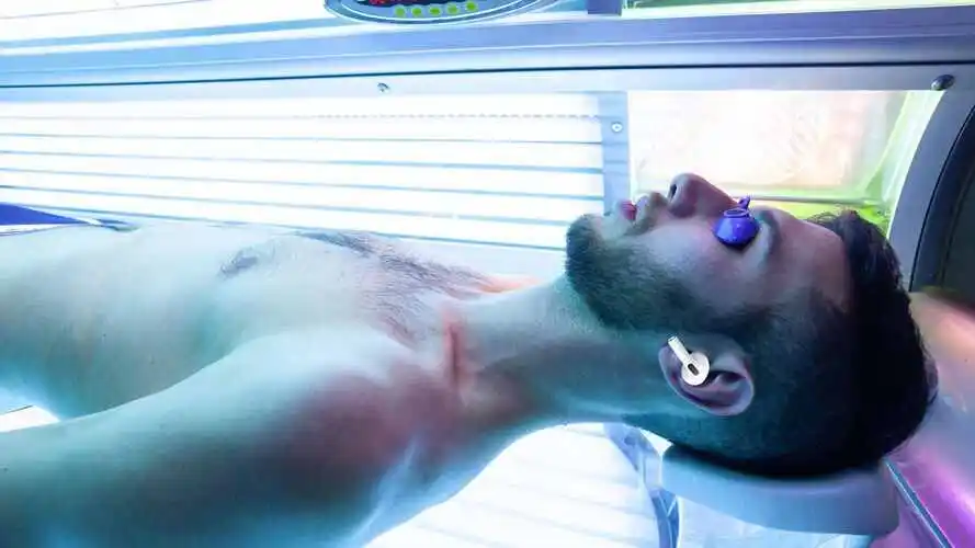 man using airpods 2nd generation in tanning bed